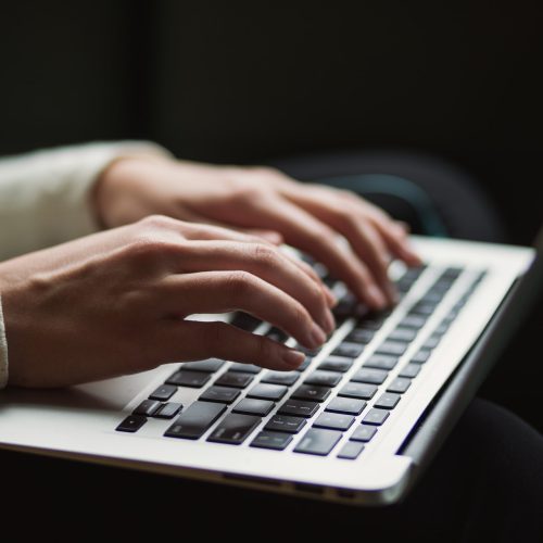 Hands typing on a keyboard.